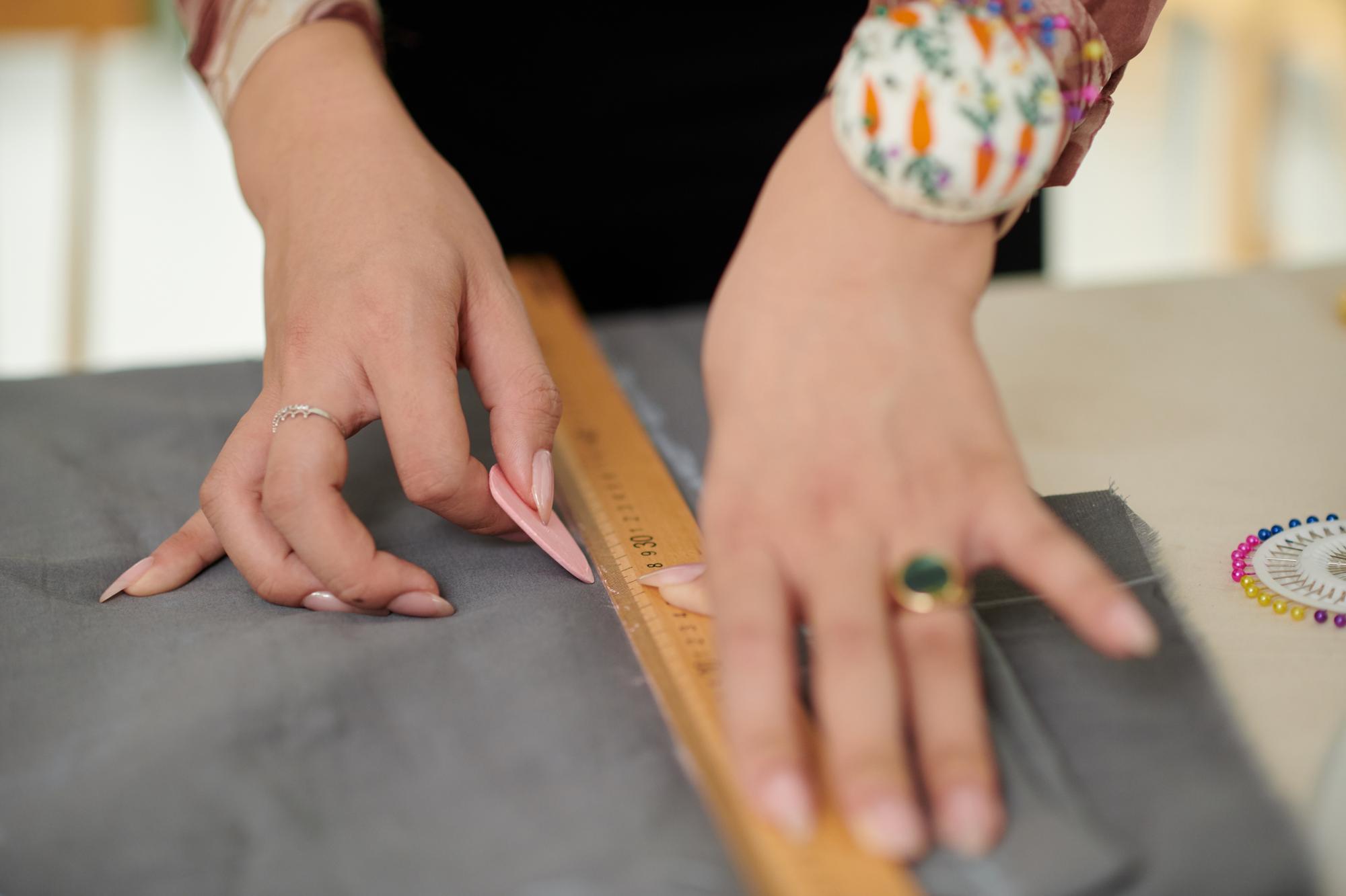 Hands measuring fabric for pricing sample